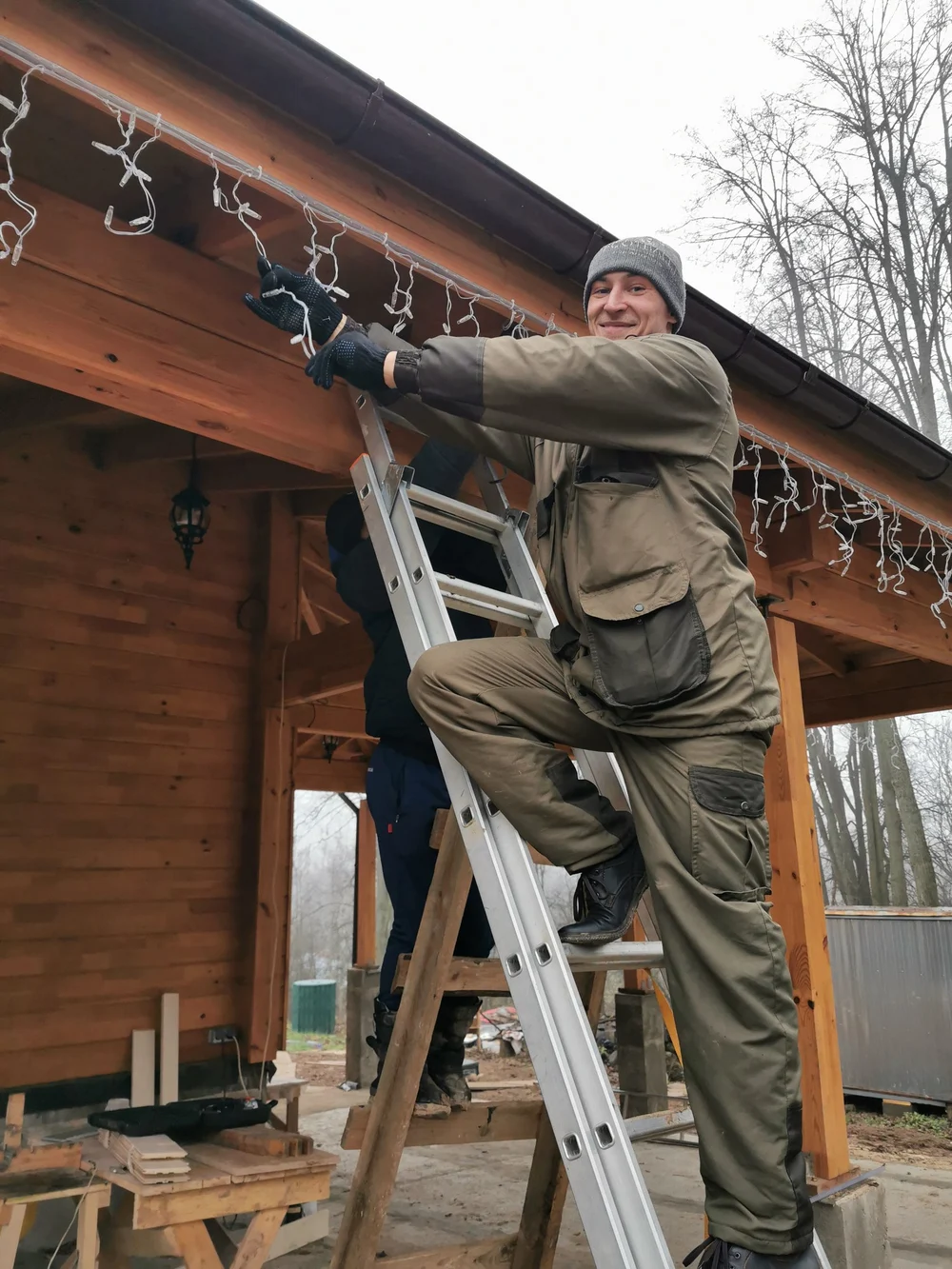 Монтаж уличной гирлянды бригадой Feel-Light с лестницы на карниз загородного дома